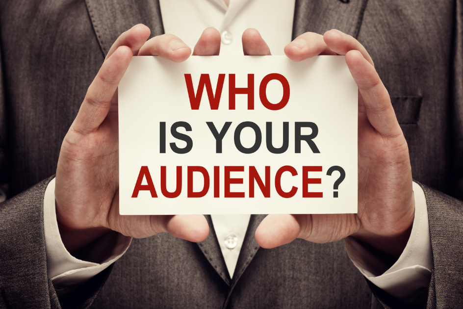 a person holding a small sign that says, "who is your audience?"